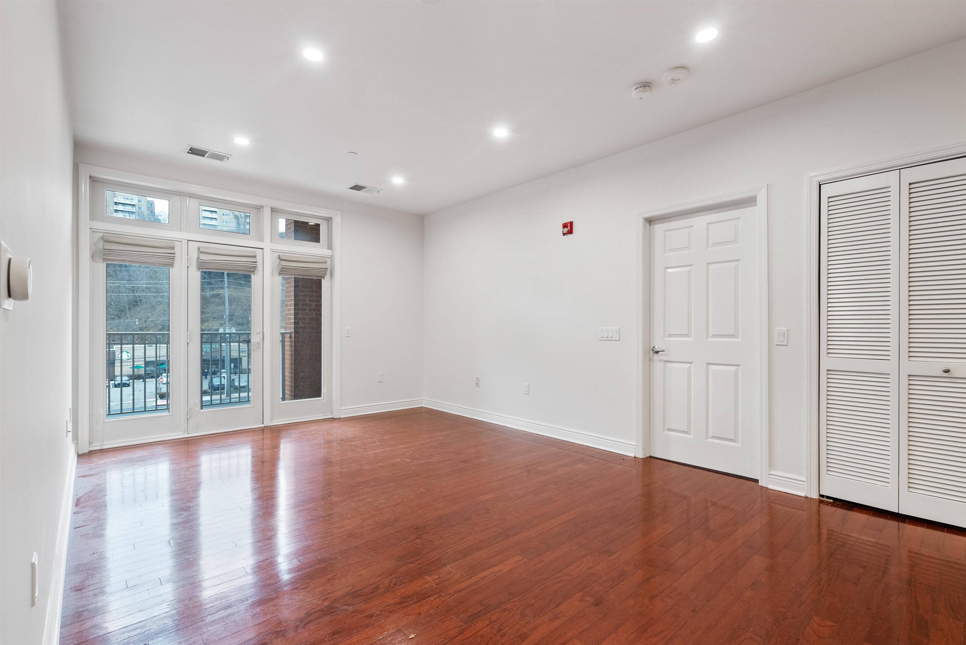 7400 River Road, Unit 317 North Bergen, NJ 07047 - Photo 7 of 41 a view of an empty room with wooden floor and windows