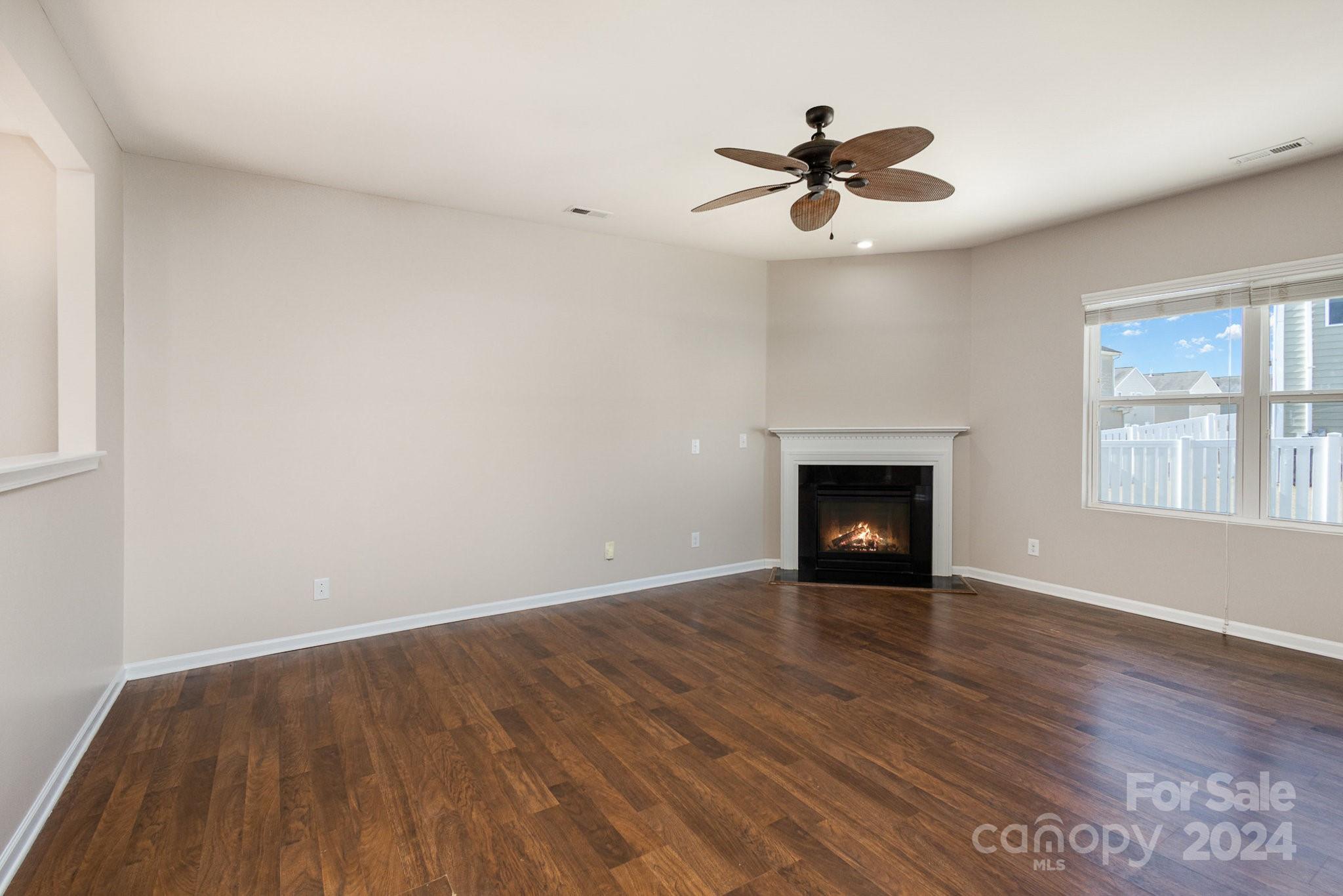 1005 Green Terra Road Indian Trail, NC 28079 - Photo 4 of 19 a view of an empty room with wooden floor fireplace and a window