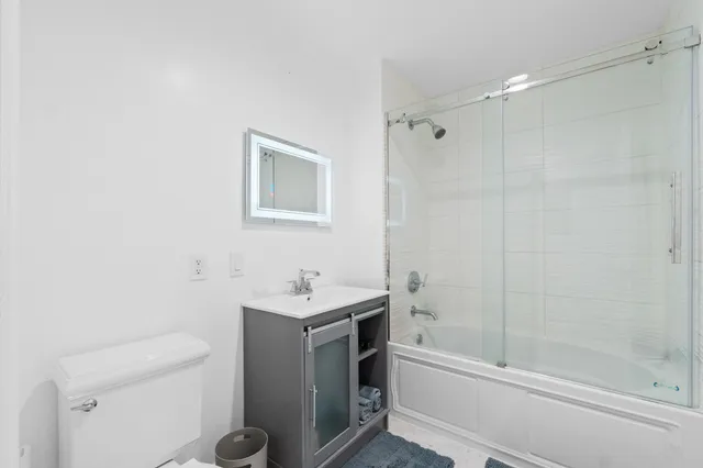 a bathroom with a sink a toilet and shower