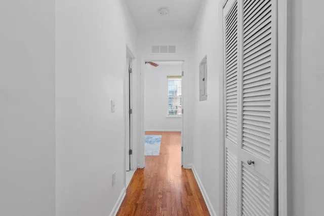 a view of a hallway with wooden floor
