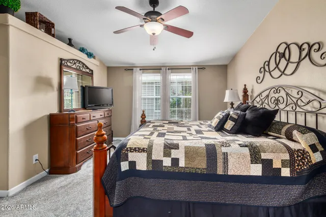 a bedroom with a bed and a flat tv screen on dresser