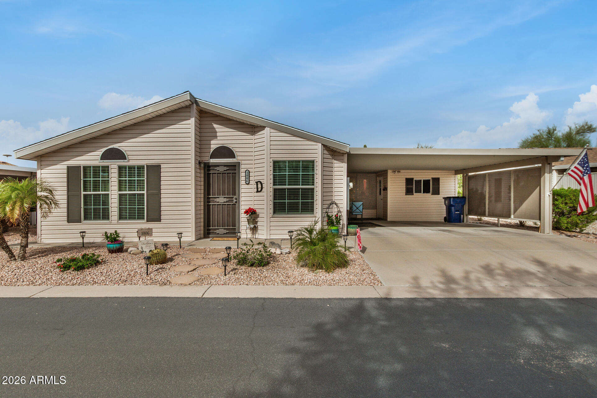 3301 South Goldfield Road, Unit 1006 Apache Junction, AZ 85119 - Photo 2 of 30 a front view of a house with a garden and patio