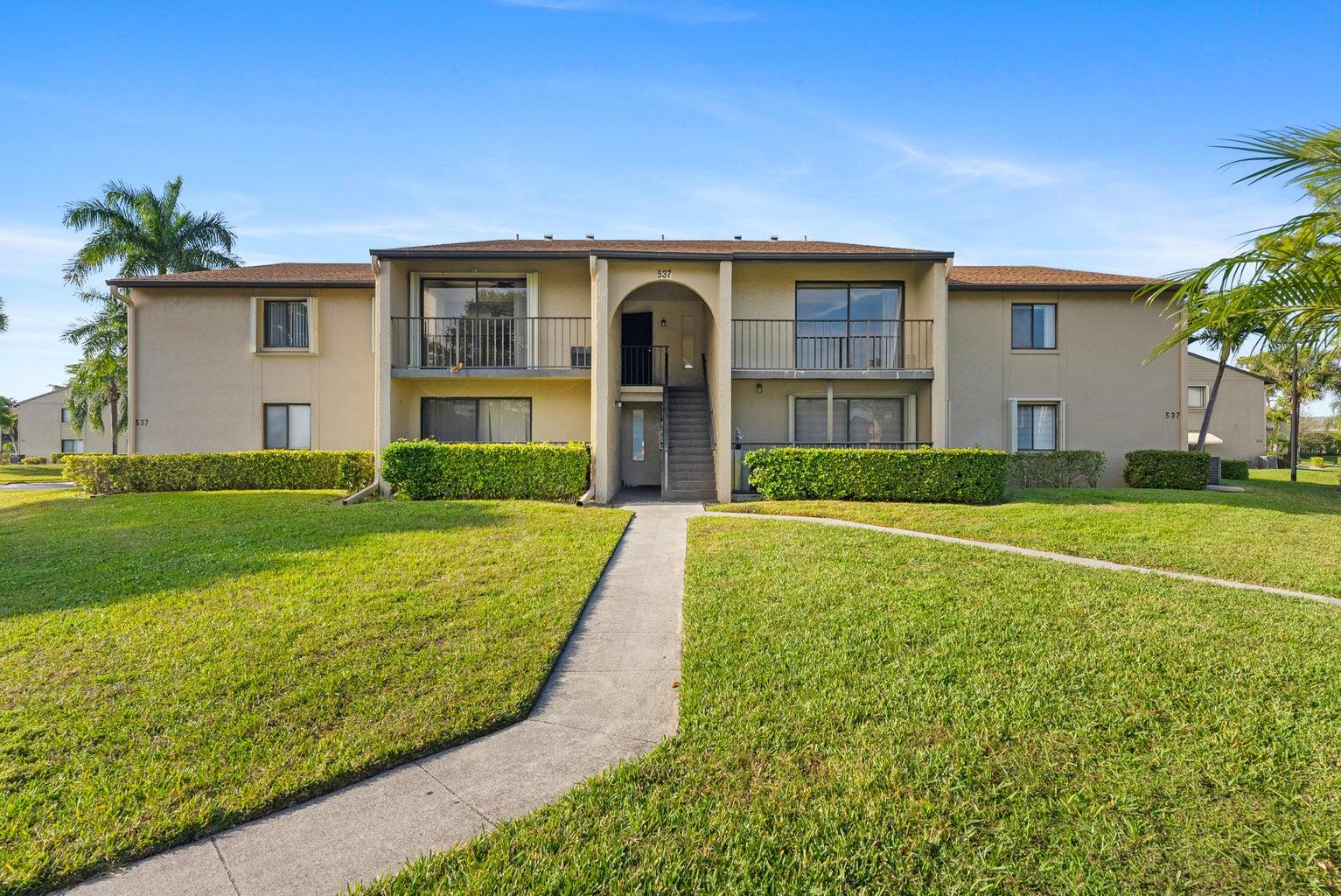537 Shady Pine Way Greenacres, FL 33415 - Photo 1 of 21 a front view of house with yard and green space