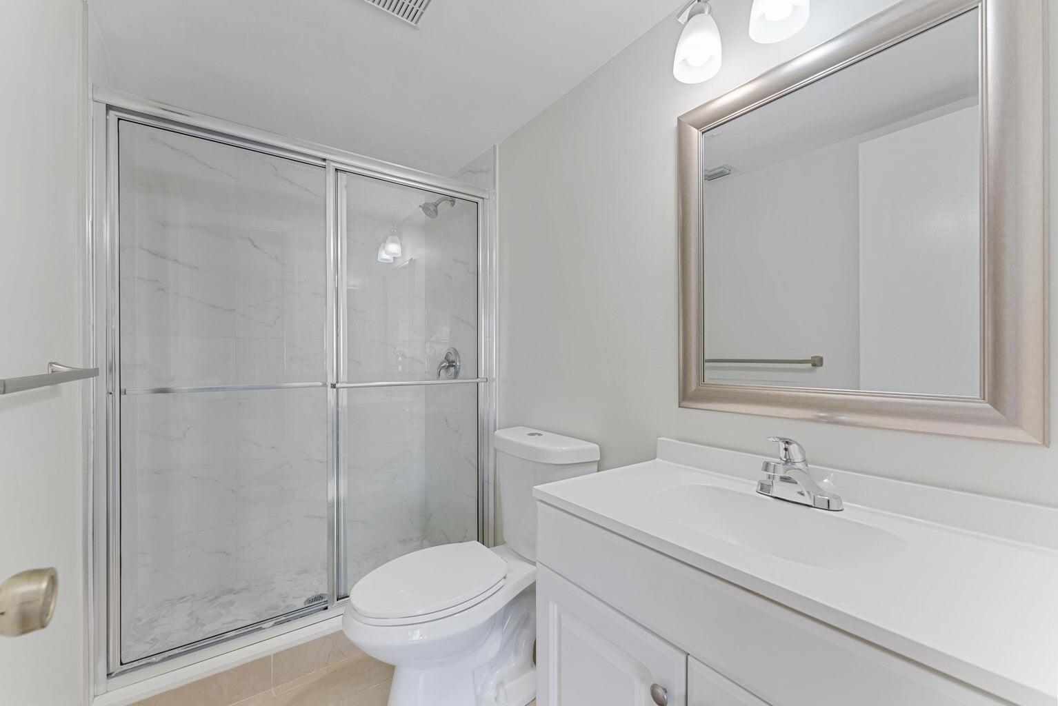 537 Shady Pine Way Greenacres, FL 33415 - Photo 11 of 21 a bathroom with a sink a toilet and a shower