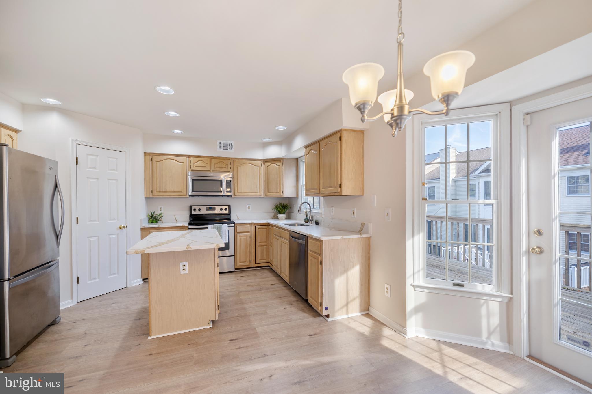 268 St Michaels Circle Odenton, MD 21113 - Photo 12 of 42 a large kitchen with kitchen island a stove a refrigerator a sink a dining table and chairs