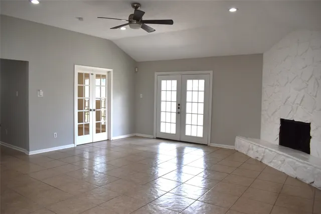 a view of an empty room with a fireplace and a window