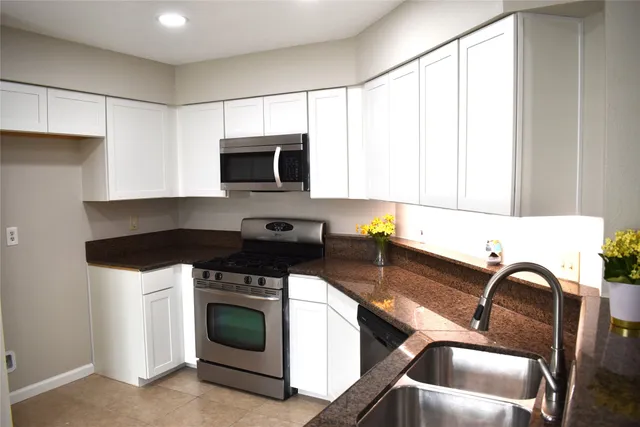 a kitchen with a refrigerator and a stove top oven