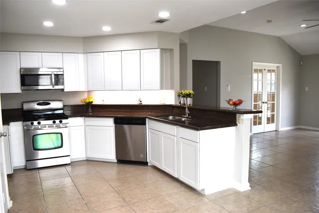 a kitchen with stainless steel appliances granite countertop a refrigerator and a stove