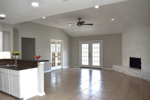 a kitchen with granite countertop a stove a sink and white cabinets