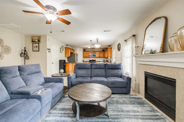 a living room with furniture a fireplace and a chandelier