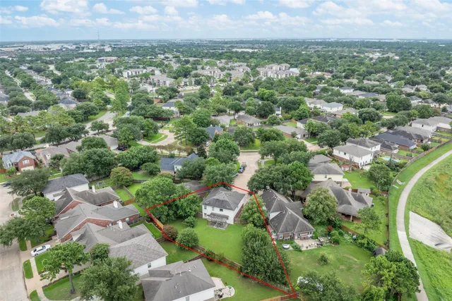 an aerial view of residential houses with outdoor space and trees