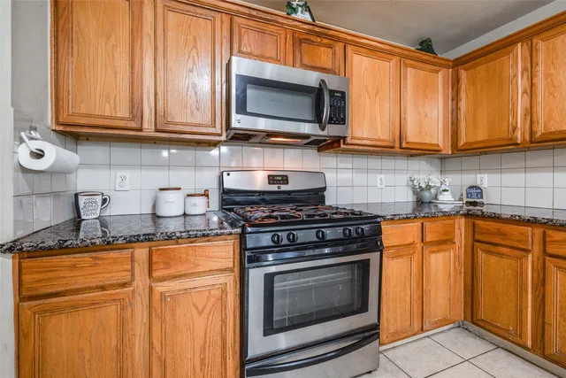 a kitchen with stainless steel appliances granite countertop a stove top oven microwave and cabinets