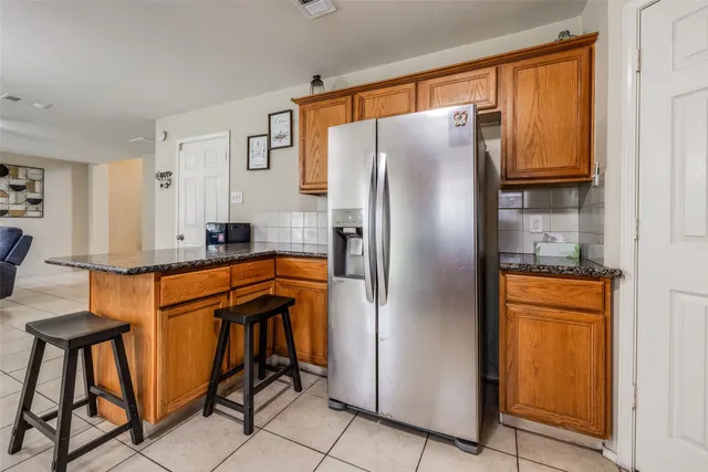 a kitchen with stainless steel appliances granite countertop a refrigerator and a stove top oven