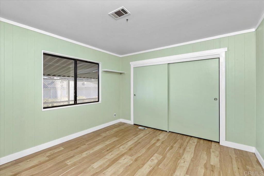 18218 Paradise Mountain Road, Unit SPC 206 Valley Center, CA 92082 - Photo 23 of 43 a view of an empty room with wooden floor and a window