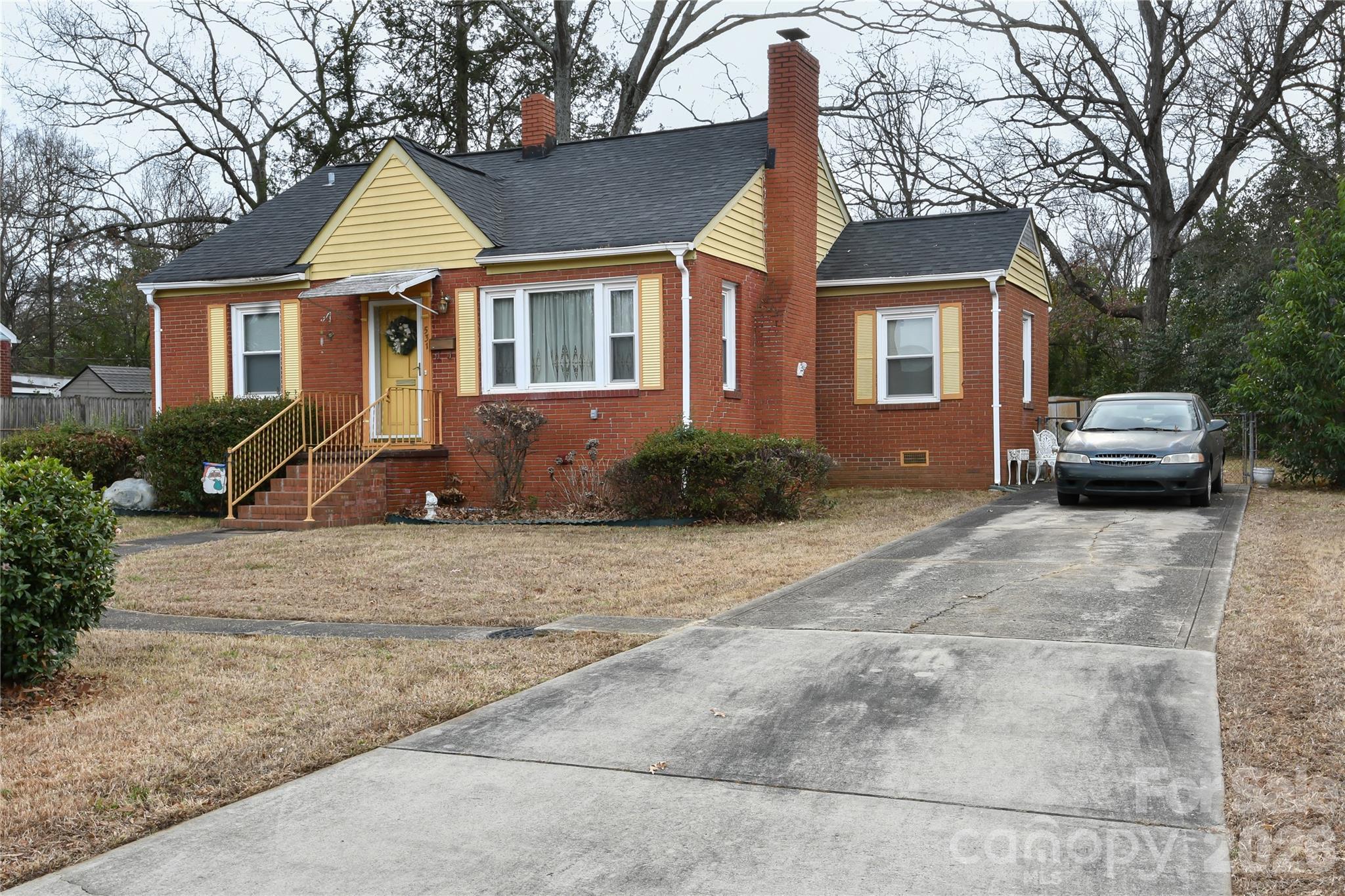 a front view of a house with cars parked