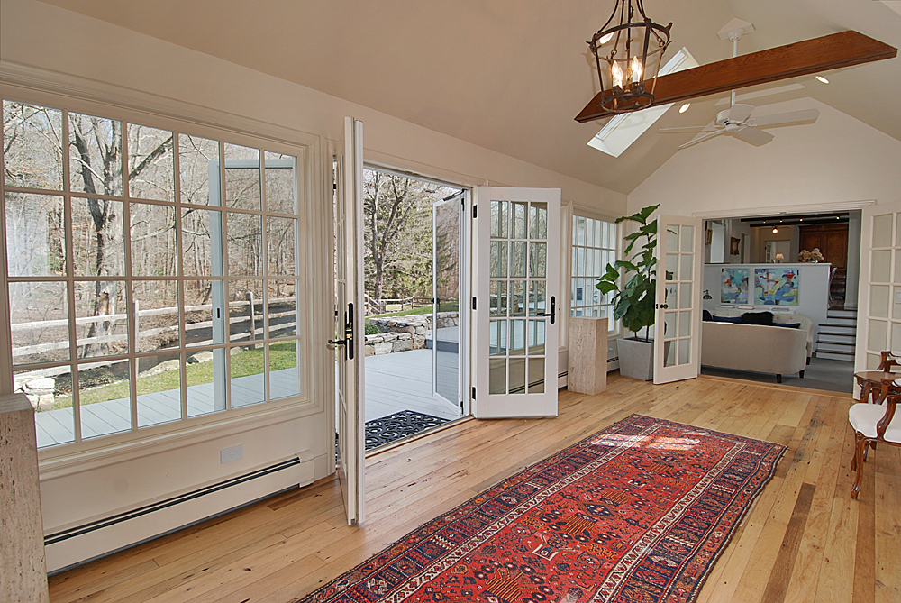 449 Valley Road New Canaan, CT 06840 - Photo 6 of 19 a living room with a rug floor to ceiling windows and wooden floor