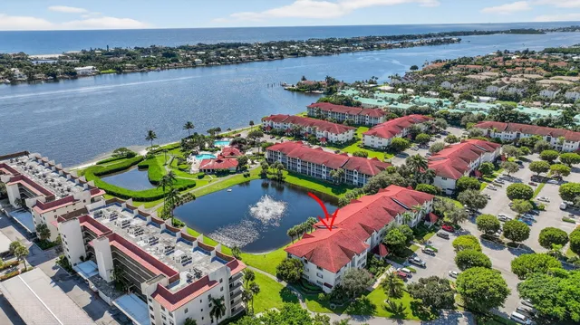 an aerial view of a house with a garden and lake view
