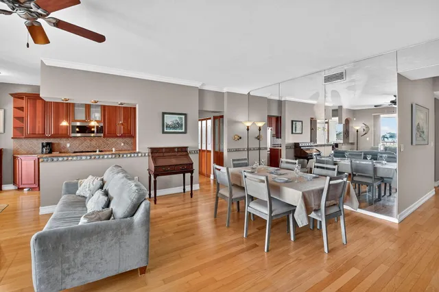 a living room with furniture kitchen and a wooden floor