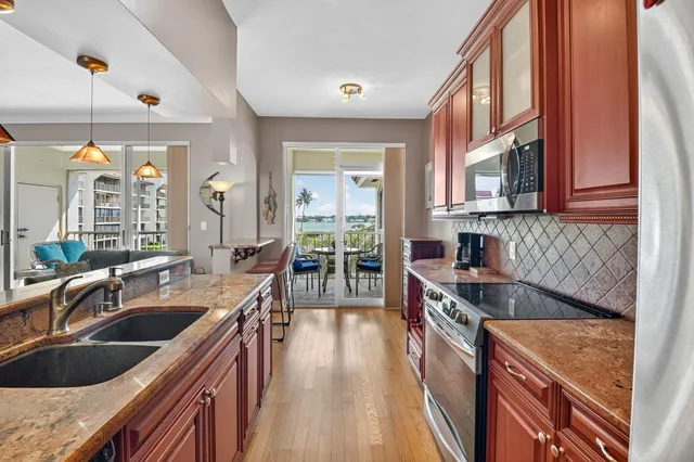 a kitchen with kitchen island granite countertop a sink stove and cabinets