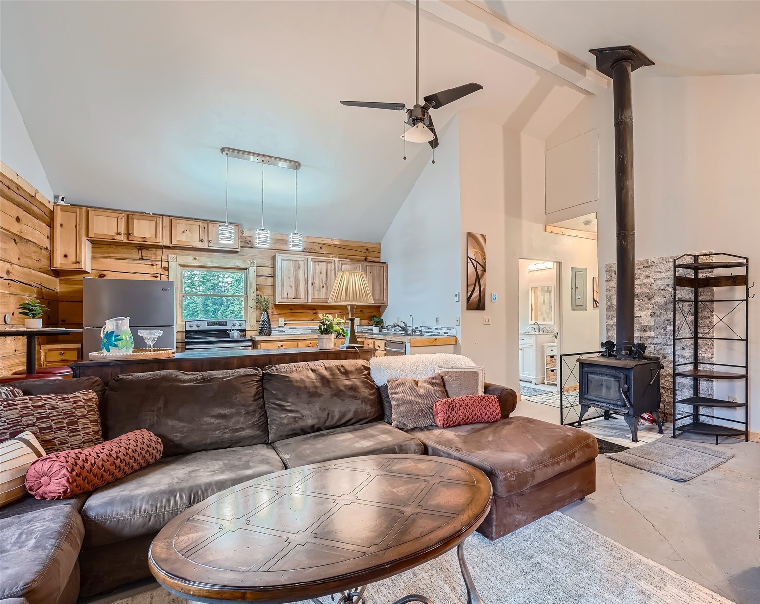 483 Bullion Mine Road Keystone, CO 80435 - Photo 7 of 28 Living room featuring ceiling fan, a wood stove, beam ceiling, and high vaulted ceiling