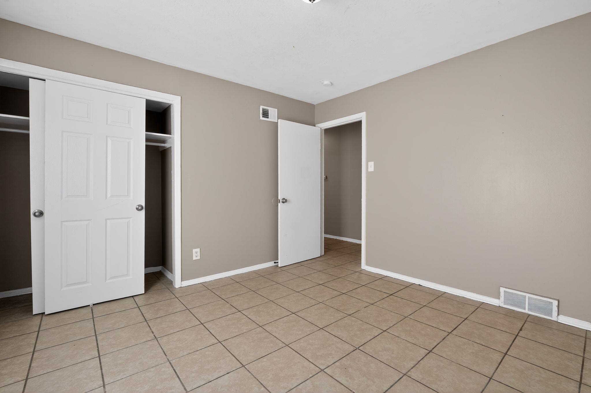 4828 Knight Arnold Road Memphis, TN 38118 - Photo 12 of 24 Unfurnished bedroom with a closet and light tile patterned floors
