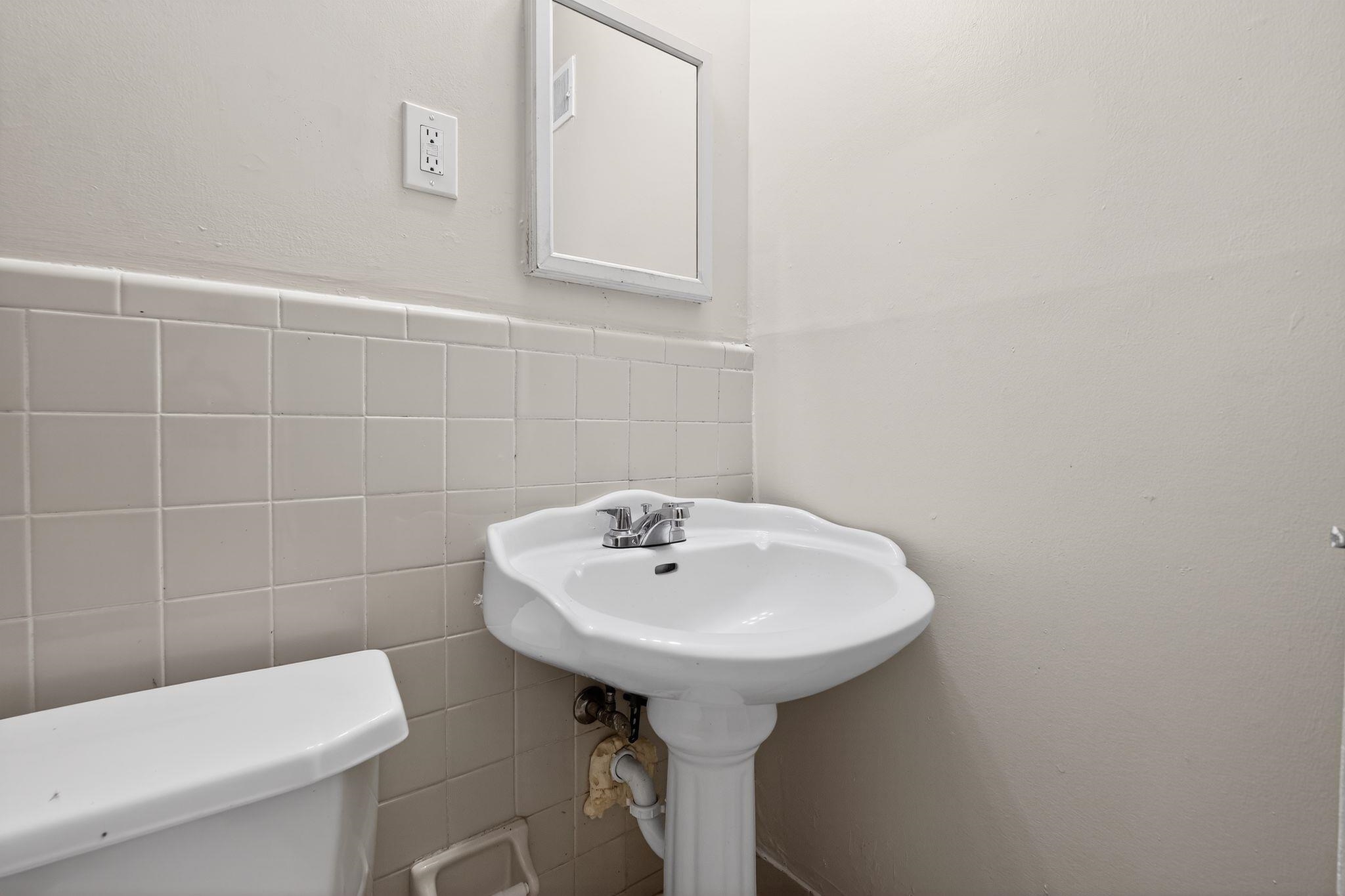 4828 Knight Arnold Road Memphis, TN 38118 - Photo 13 of 24 Half bathroom with tile walls and wainscoting
