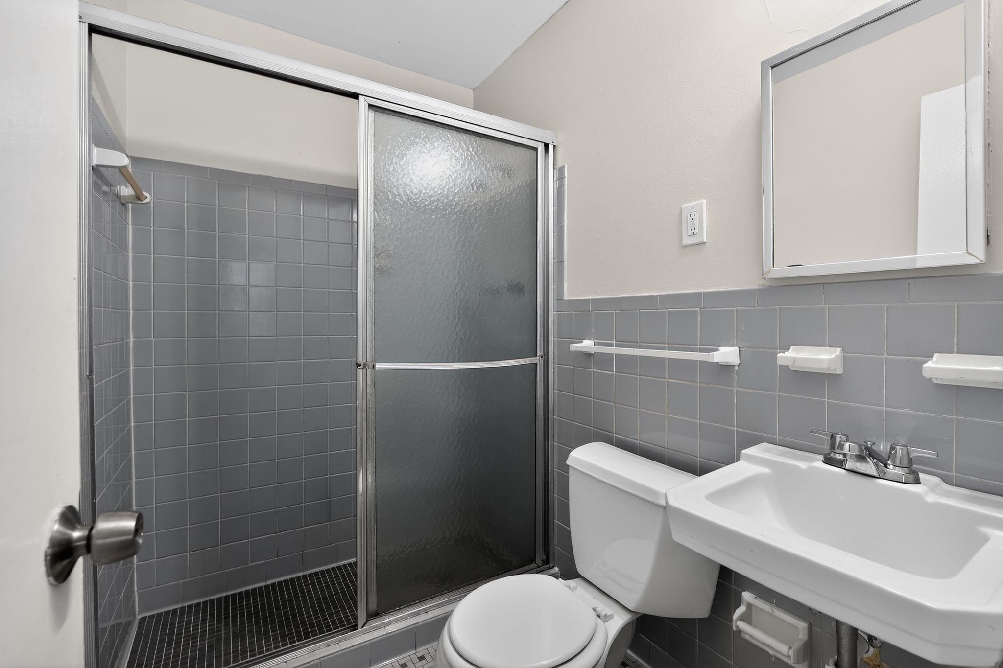 4828 Knight Arnold Road Memphis, TN 38118 - Photo 14 of 24 Full bathroom with tile walls, a shower stall, and a wainscoted wall