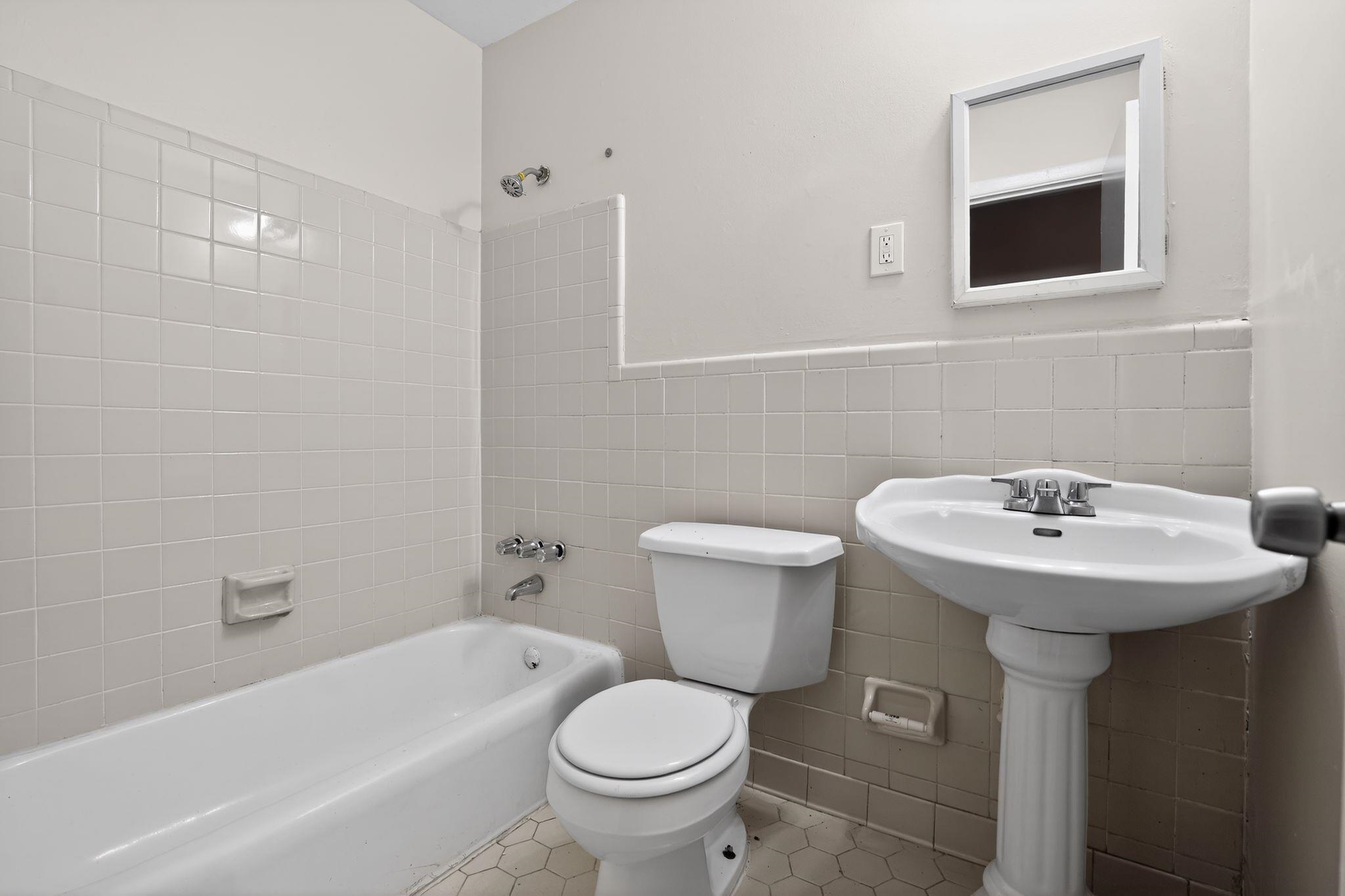 4828 Knight Arnold Road Memphis, TN 38118 - Photo 15 of 24 Bathroom with tile walls, bathing tub / shower combination, and wainscoting