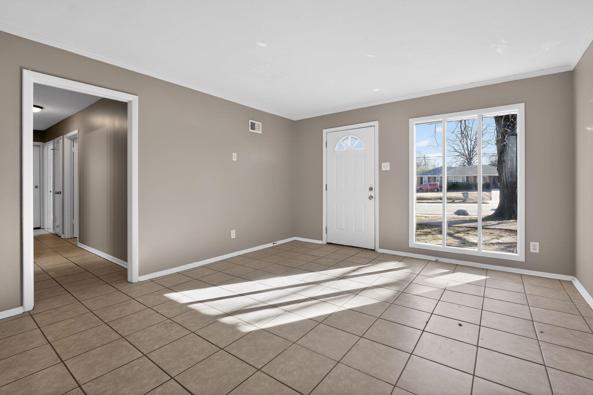 4828 Knight Arnold Road Memphis, TN 38118 - Photo 4 of 24 Foyer entrance with crown molding and light tile patterned flooring