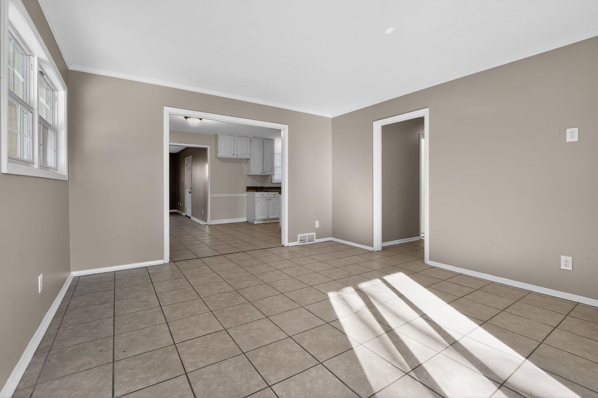 4828 Knight Arnold Road Memphis, TN 38118 - Photo 7 of 24 Empty room featuring light tile patterned flooring and crown molding