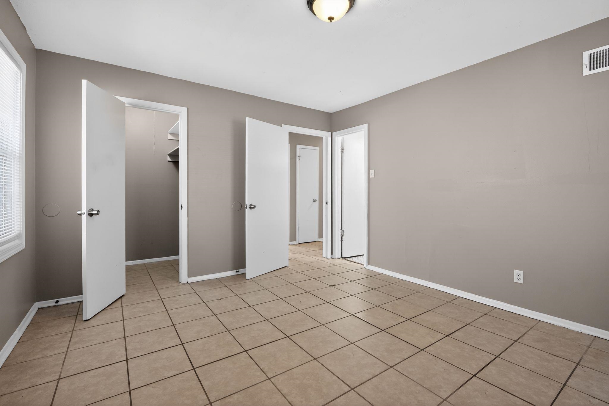 4828 Knight Arnold Road Memphis, TN 38118 - Photo 10 of 24 Unfurnished bedroom featuring a spacious closet and light tile patterned floors