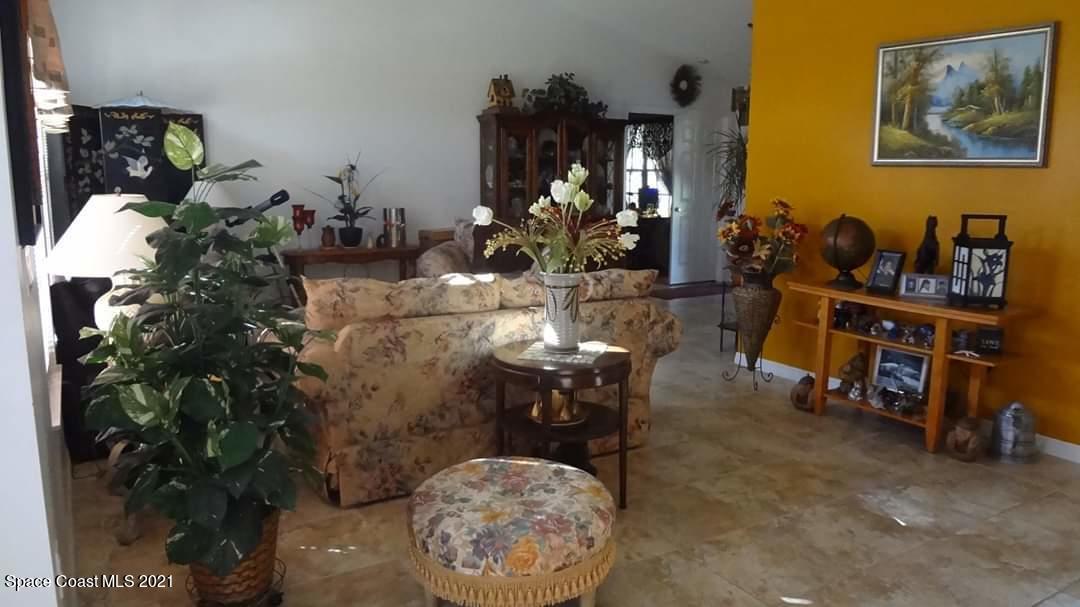 714 Seymour Road Northeast Palm Bay, FL 32905 - Photo 2 of 5 a living room with furniture a potted plant and a large mirror