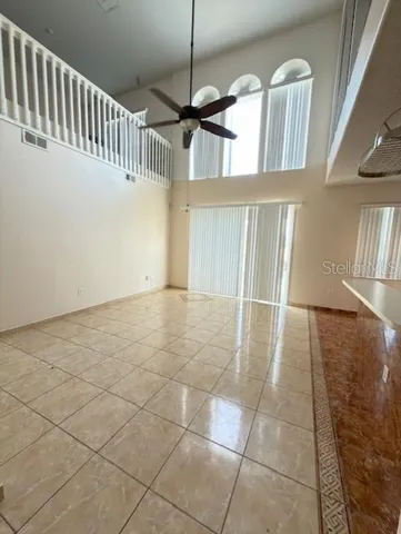 a view of a livingroom with wooden floor and a ceiling fan