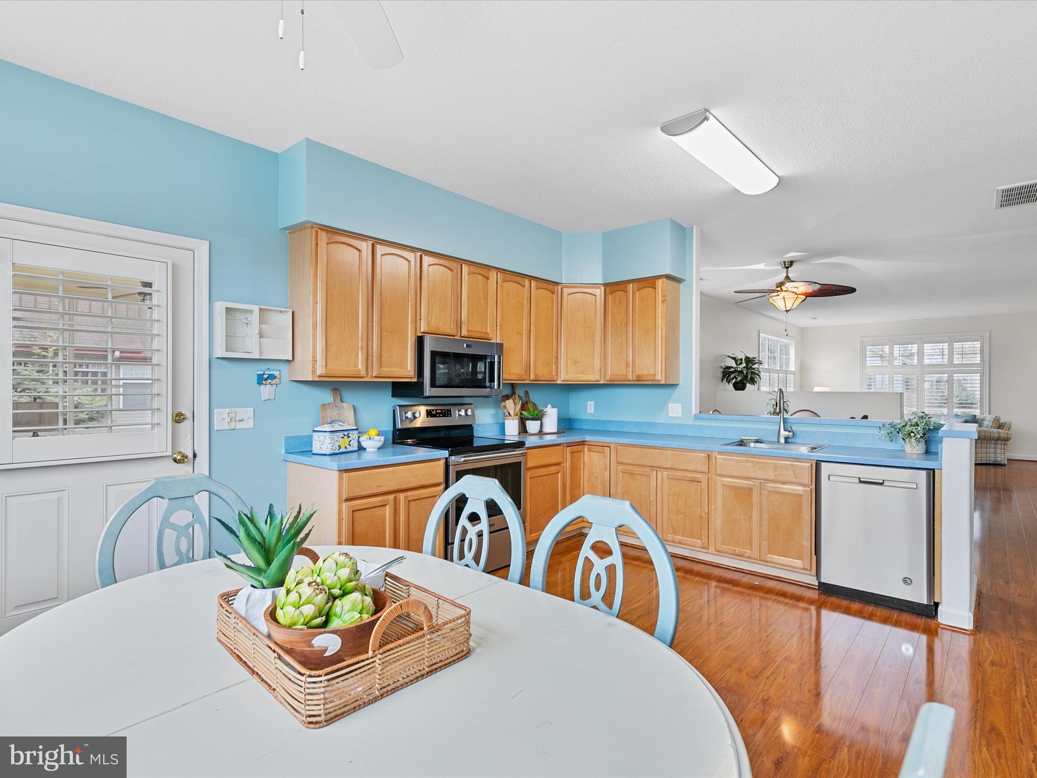 4 Cromwell Drive Ocean View, DE 19970 - Photo 16 of 59 a kitchen with stainless steel appliances granite countertop a stove top oven a dining table and chairs with wooden floor