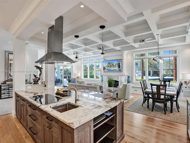 a kitchen with stainless steel appliances granite countertop a stove oven a dining table and chairs with wooden floor