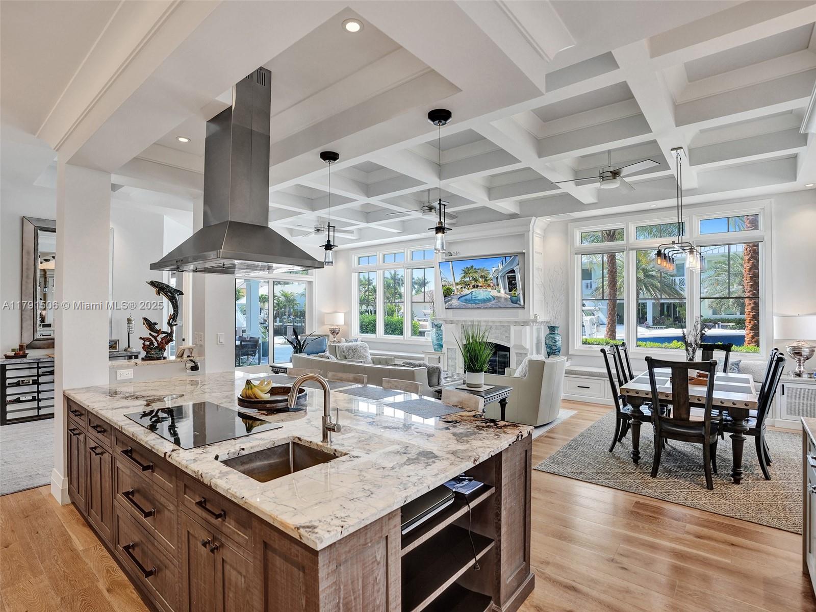 2340 Northeast 48th Street Lighthouse Point, FL 33064 - Photo 13 of 48 a kitchen with stainless steel appliances granite countertop a stove oven a dining table and chairs with wooden floor