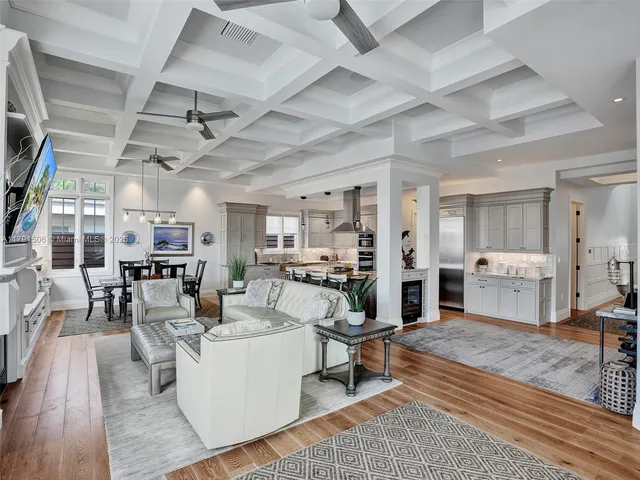 a living room with lots of furniture and view of kitchen appliances