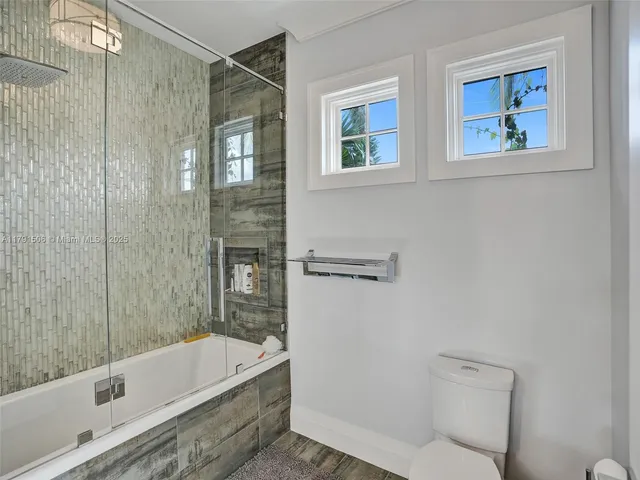 a bathroom with a tub a toilet and a shower