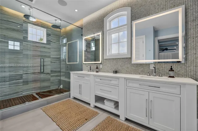 a spacious bathroom with a double vanity sink a mirror and a shower
