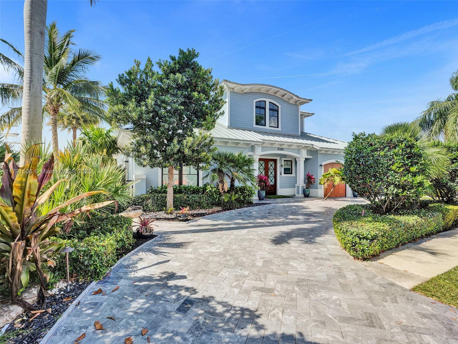 2340 Northeast 48th Street Lighthouse Point, FL 33064 - Photo 6 of 48 a front view of a house with a yard