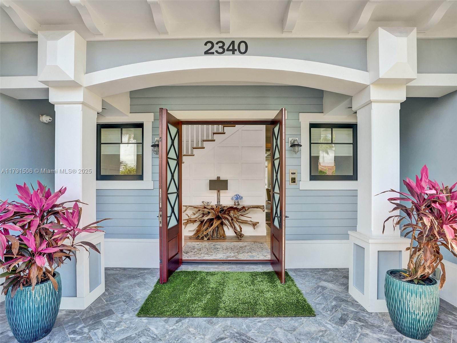 2340 Northeast 48th Street Lighthouse Point, FL 33064 - Photo 7 of 48 a front view of a house with a garden