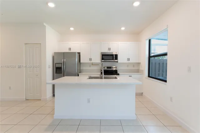 a large kitchen with cabinets and stainless steel appliances