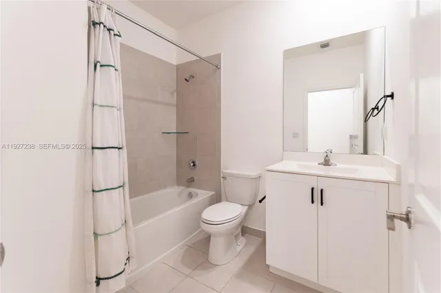 a bathroom with a granite countertop sink a toilet and shower