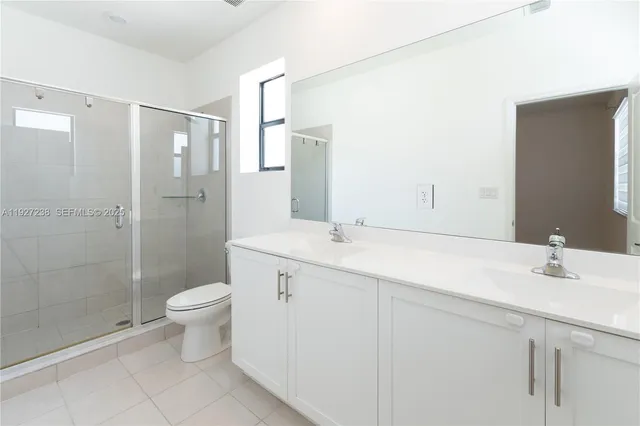 a bathroom with a double vanity sink toilet and shower