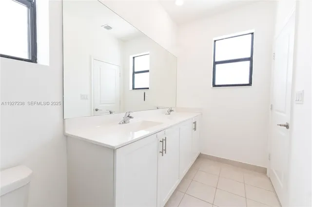 a view of a bathroom with 2 sink and a mirror