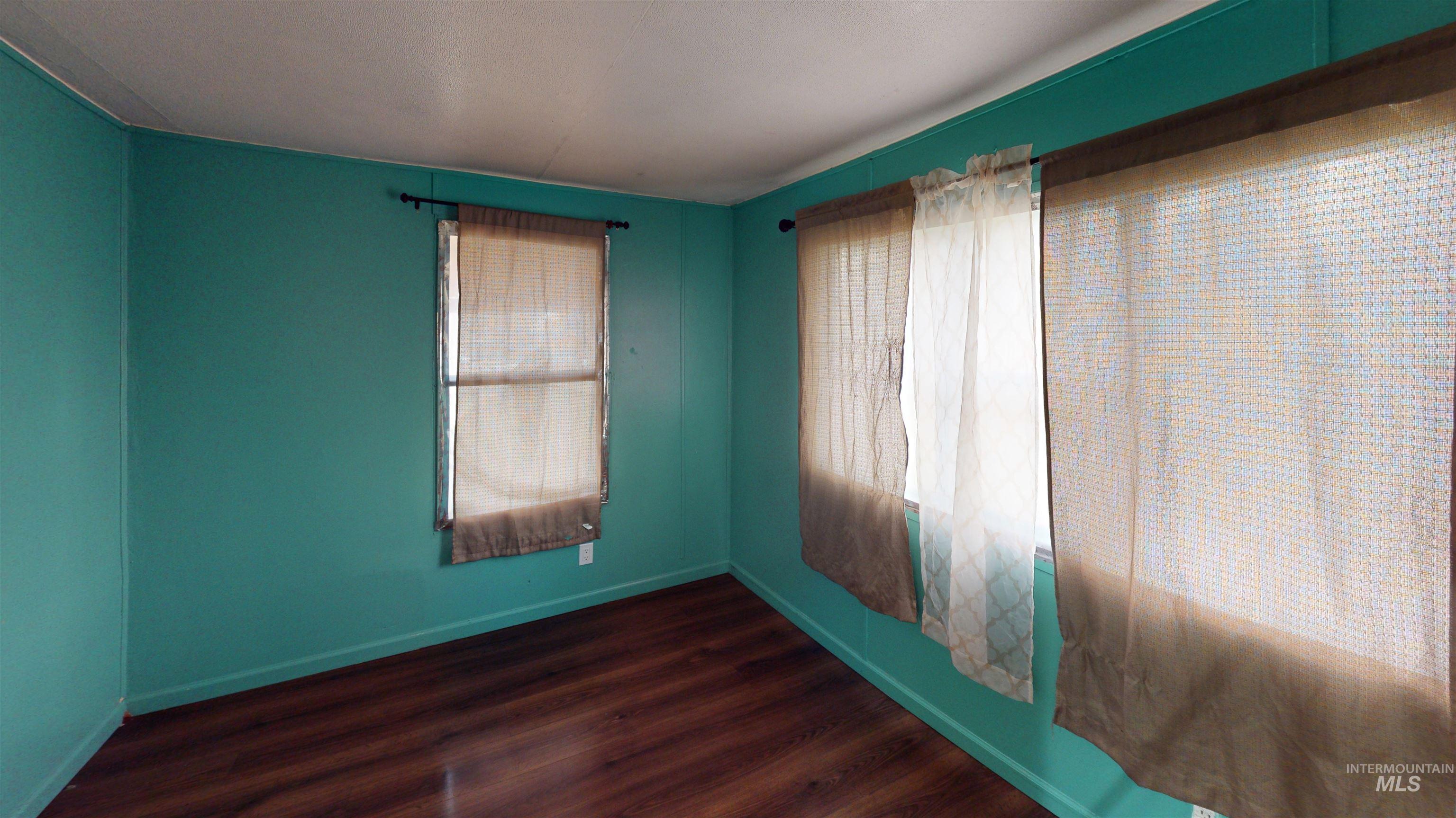 19151 Symms Road Caldwell, ID 83607 - Photo 12 of 14 Spare room featuring dark wood-type flooring and baseboards