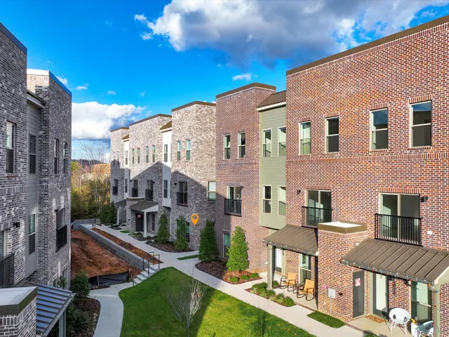 a front view of a residential apartment building with a yard