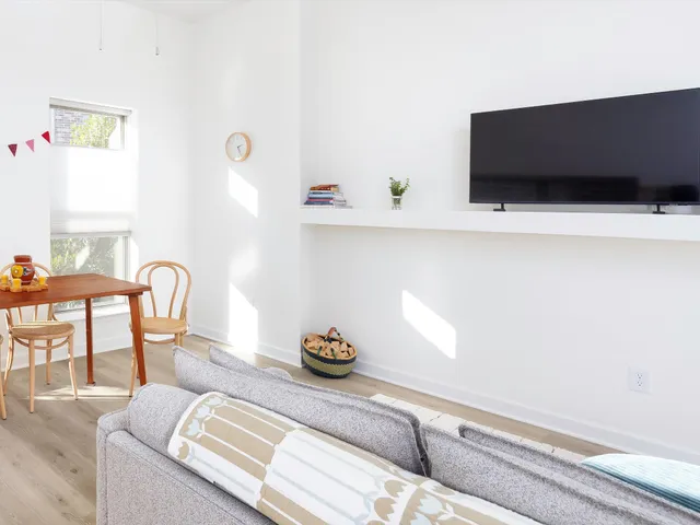 a living room with furniture kitchen view and a window