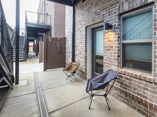 a backyard of a house with barbeque oven table and chairs