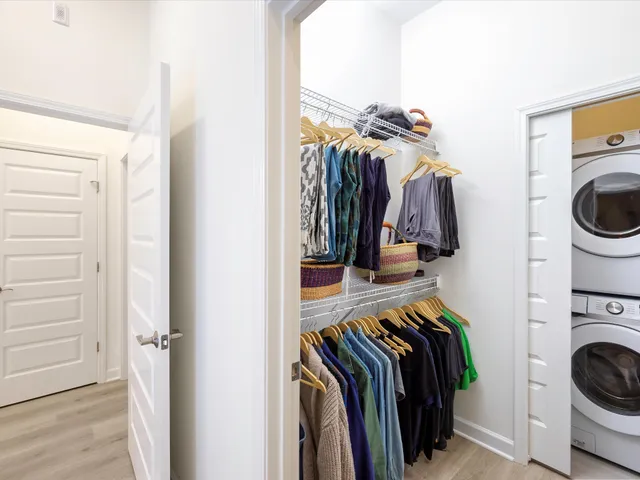 a bedroom with a bed and a chair with the potted plant